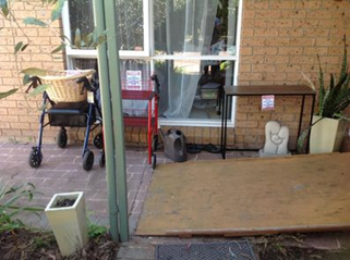 A ramp is at the front of a house and modified walkers are by the window.